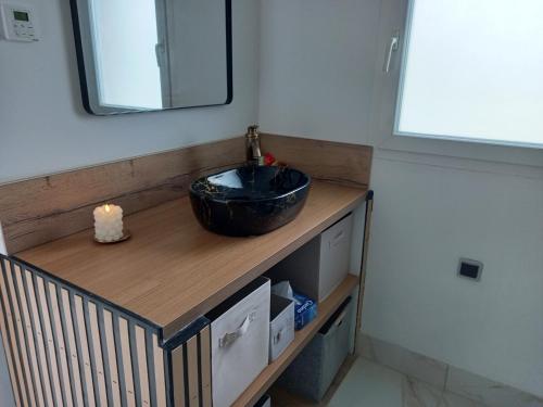 une salle de bain avec un lavabo noir et un miroir dans l'établissement Appartement F2, à Bastia