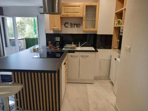 une cuisine avec des armoires blanches et un comptoir noir dans l'établissement Appartement F2, à Bastia