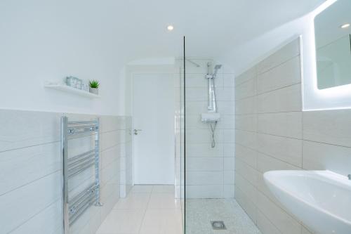 baño blanco con ducha y lavamanos en The Large Group House -Sleeps 21, en Dublín