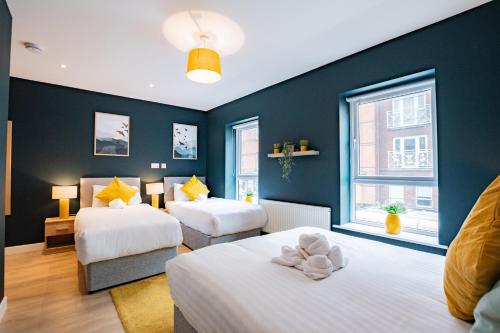 2 camas en una habitación con paredes azules en The Large Group House -Sleeps 21, en Dublín