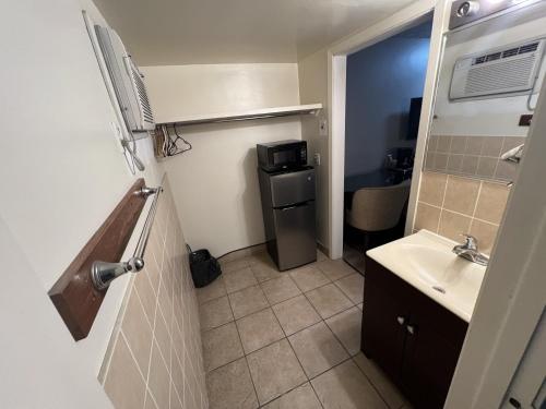 a small bathroom with a sink and a refrigerator at Choice Inn by the falls in Niagara Falls