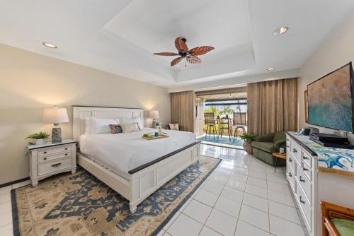a bedroom with a king sized bed and a tv at Eldorado L202 in Kahana