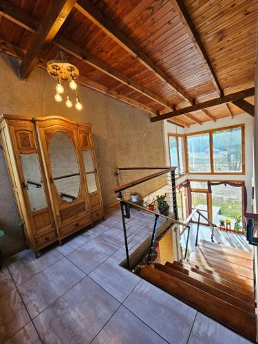 a living room with a staircase and a wooden ceiling at La Reina Hotel in Santa Rosa de Calamuchita