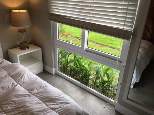 Dormitorio con ventana, cama y lámpara en Villa Ocean Pearl Venao, en Playa Venao