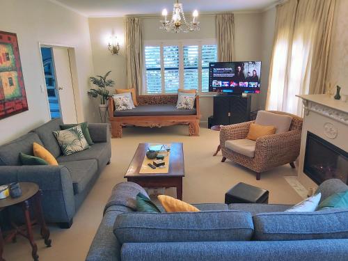 a living room with blue couches and a tv at Haven Homestay Rotorua in Rotorua