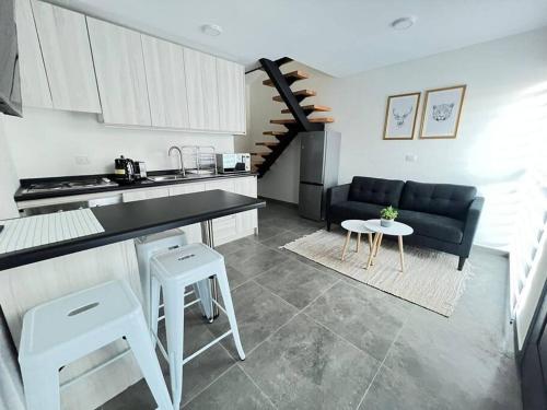 a kitchen and living room with a couch and a table at Austral Apartment Regional in Valdivia
