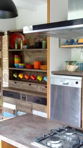 - une cuisine avec une cuisinière et des bols sur une étagère dans l'établissement Charmante Maison de Campagne Proche de Bergerac, Sites de Dordogne, Randonnées, à Sadillac