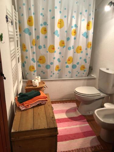 a bathroom with a toilet and a shower curtain at Chalés na Montanha - casa do lado - Serra da Estrela in Manteigas