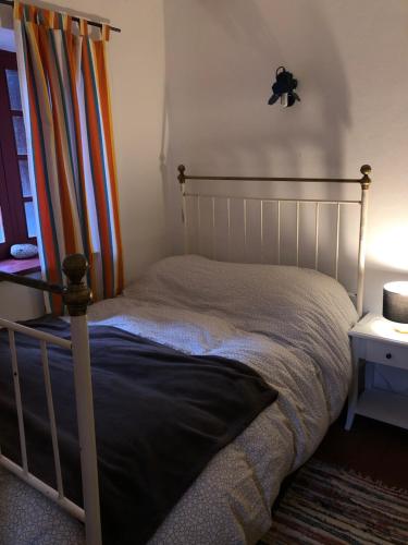 a bed in a bedroom with a bed frame and a window at Chalés na Montanha - casa do lado - Serra da Estrela in Manteigas