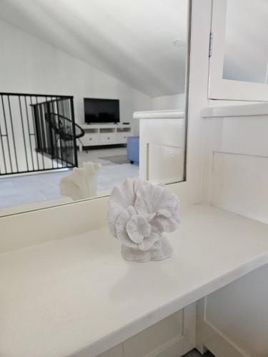 a white counter with a flower on it in front of a mirror at Vila Brod in Šibenik