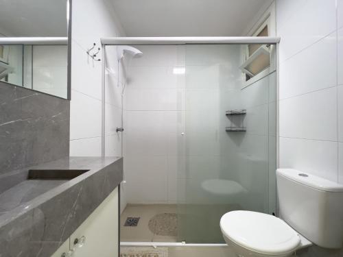 a bathroom with a toilet and a glass shower at Vista espetacular beira mar - Capão da Canoa in Capão da Canoa