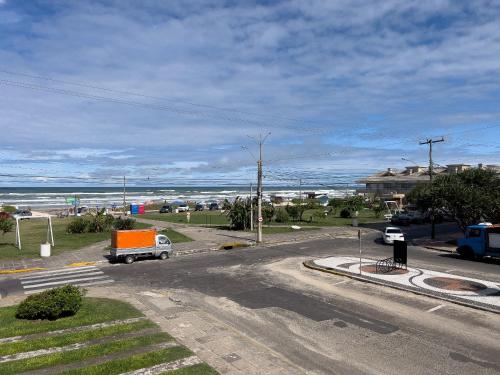 a truck driving down a road near the ocean at Vista espetacular beira mar - Capão da Canoa in Capão da Canoa