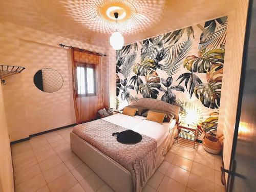 a bedroom with a bed with a tropical wallpaper at Arcadia Golden Bay in Giardini Naxos