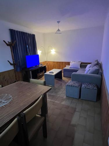 ein Wohnzimmer mit Couch und Tisch in der Unterkunft CASA DE BARRIO LUJAN DE CUYO in Ciudad Lujan de Cuyo