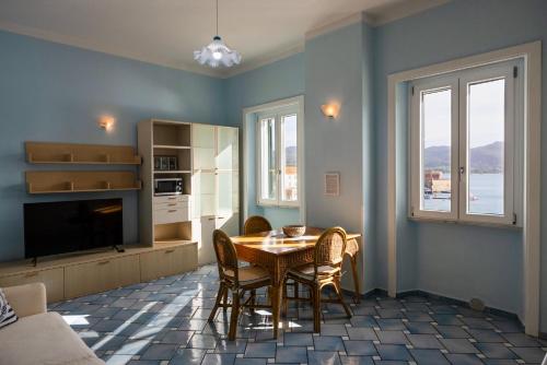 uma sala de estar com uma mesa e cadeiras e uma televisão em La Casina Azzurra Sul Mare em Portoferraio