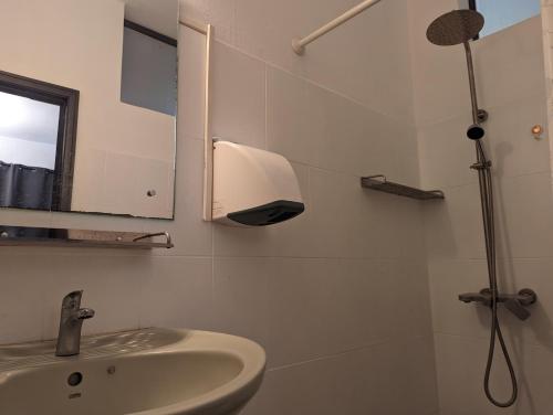 格蘭貝伊的住宿－Residence Keoli，白色的浴室设有水槽和淋浴。