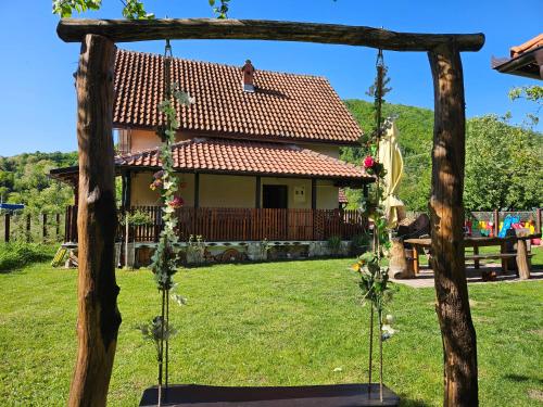 a swing in front of a house at Drinska Dedovina in Gornja Trešnjica