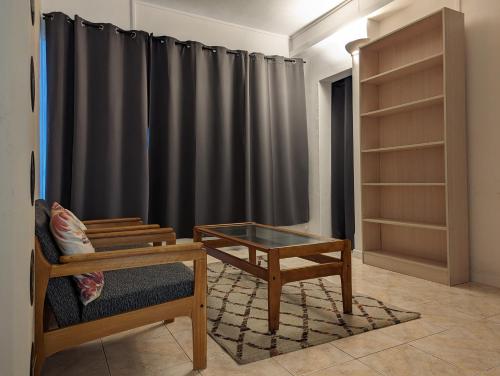 格蘭貝伊的住宿－Residence Keoli，客厅配有桌子和黑色窗帘