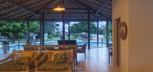 een woonkamer met een tafel en stoelen en een zwembad bij House Anthony and Cleusa 36 Quinta do Rio in Pipa