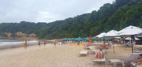 een strand met mensen op stoelen en parasols bij House Anthony and Cleusa 36 Quinta do Rio in Pipa