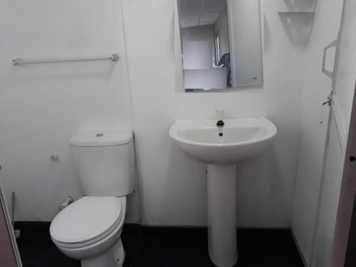 a white bathroom with a toilet and a sink at Sky House by the Bentota Beach in Bentota