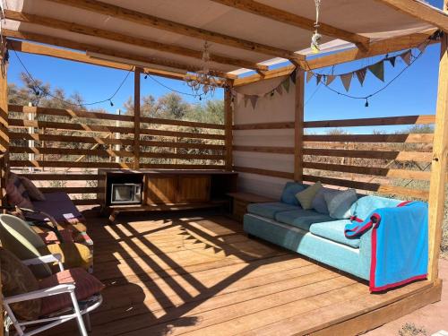 a screened in porch with a couch and a fireplace at Retiro Bajoestrellas in San Pedro de Atacama