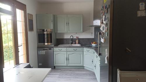  La cuisine est équipée de placards blancs et d'un réfrigérateur. dans l'établissement Piscine chaufée à proximité de Blois et du zoo de Beauval, à Saint-Bohaire