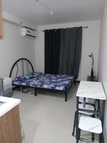 Habitación con cama, mesa y silla en Haven of Deities Property Rental, en Lapu Lapu City