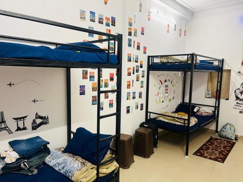 Habitación con 2 literas y una pared con carteles. en Spiritual Backpackers Hostel en Ujjain