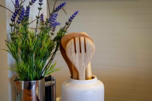 a wooden spatula sitting next to a vase with flowers at Blissful Birchs Bay - Gorgeous 3 Bedroom House in Woodbridge
