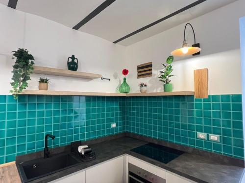 eine Küche mit Spüle und grünen Fliesen in der Unterkunft Amay City Suite in Bari