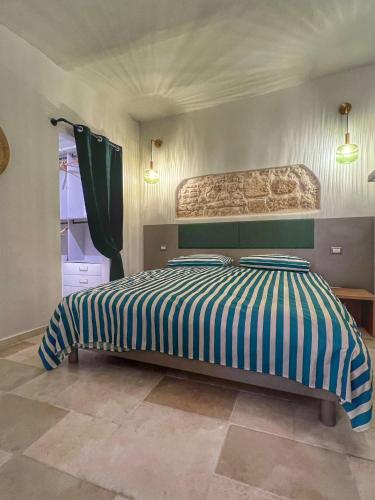 a bedroom with a bed with blue and white stripes at Amay City Suite in Bari