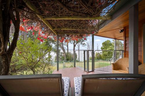 a screened in porch with a table and chairs at Blissful Birchs Bay - Gorgeous 3 Bedroom House in Woodbridge