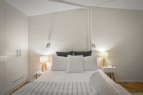 a bedroom with a large white bed with two lamps at Blissful Birchs Bay - Gorgeous 3 Bedroom House in Woodbridge