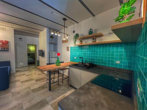 eine Küche mit einem Tisch und grünen Fliesen in der Unterkunft Amay City Suite in Bari