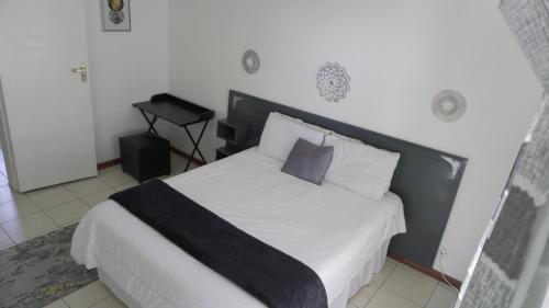 a bedroom with a bed with a black and white headboard at Daffodils Haven in Gaborone