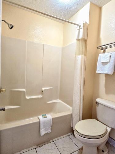 a bathroom with a toilet and a tub and a sink at Garden Inn and Suites near Callaway Gardens Pine Mountain in Pine Mountain