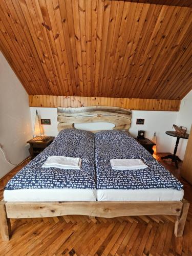 a bed in a room with a wooden ceiling at Drinska Dedovina in Gornja Trešnjica