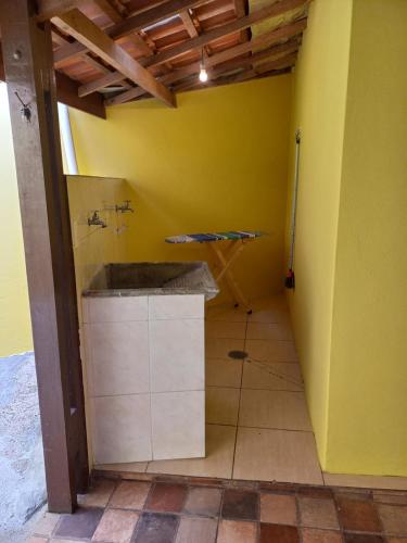 baño con lavabo y pared amarilla en Casa Recanto 3, en Campos do Jordão