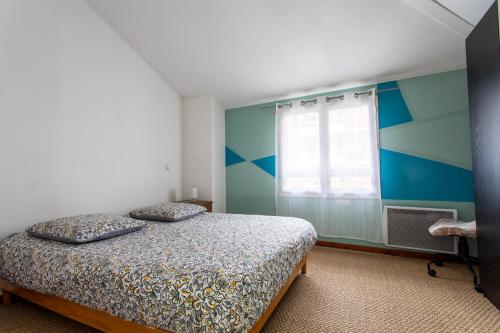 - une chambre avec un lit et un mur bleu et blanc dans l'établissement T2 Toulouse 40m2, Lit Queen Size, Climatisation, quartier sympa, Terrasse, à Toulouse