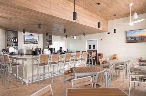 un restaurante con mesas y sillas y un bar en Summer Breeze at Lost Key Golf & Beach Club, en Pensacola