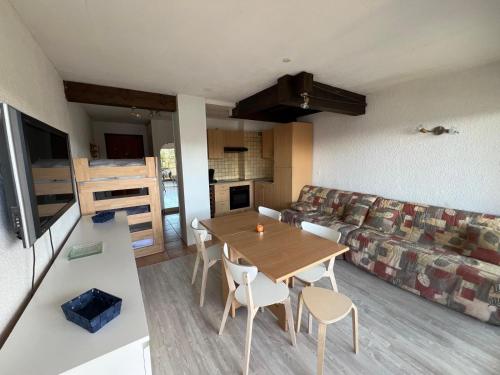 een woonkamer met een tafel en een bank bij L'ALPE D'HUEZ Appartement 4 couchages idéalement situé in Huez