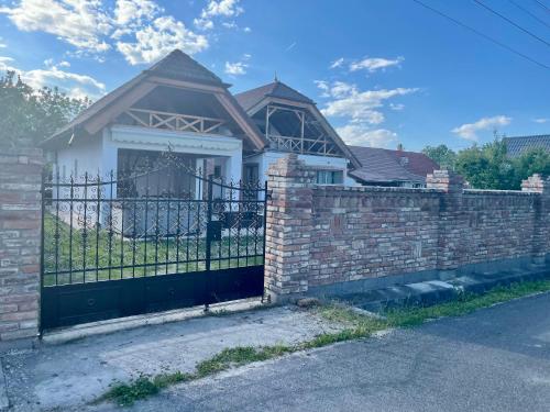 a brick fence with a gate in front of a house at Mariska in Balatonkeresztúr