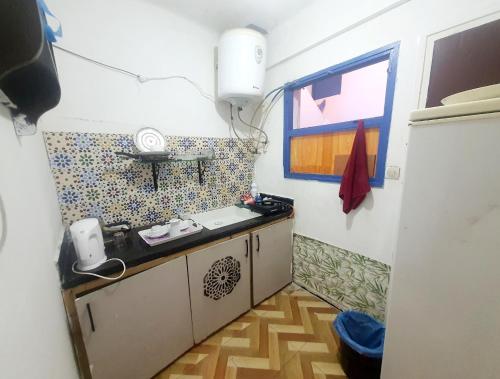 małą kuchnię ze zlewem i oknem w obiekcie Studiozentrum Agadir. w mieście Agadir