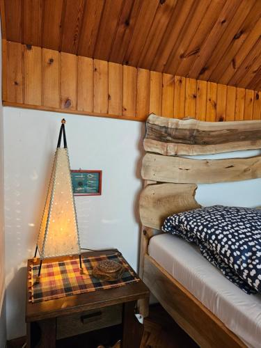 a bedroom with a bed and a table with a lamp at Drinska Dedovina in Gornja Trešnjica