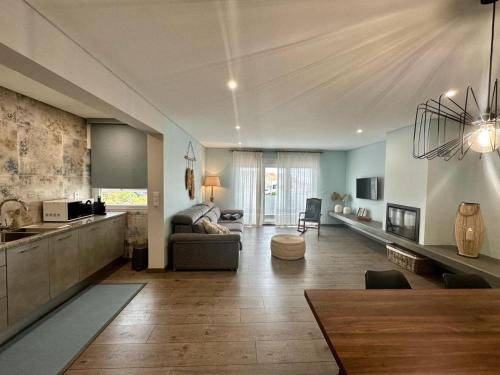a large living room with a couch and a kitchen at Beach Retreat in Torres Vedras