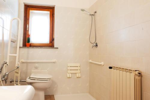 a white bathroom with a toilet and a sink at Hotel L'Aragosta in La Caletta