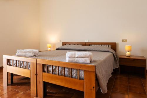 a bedroom with a bed with two towels on it at Hotel L'Aragosta in La Caletta