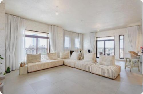 sala de estar amplia con 2 sofás y ventanas en PENTHOUSE BURJ AL ARAB FRONT en Dubái
