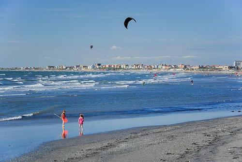two people on the beach flying a kite at Sottomarina Beach Life in Sottomarina